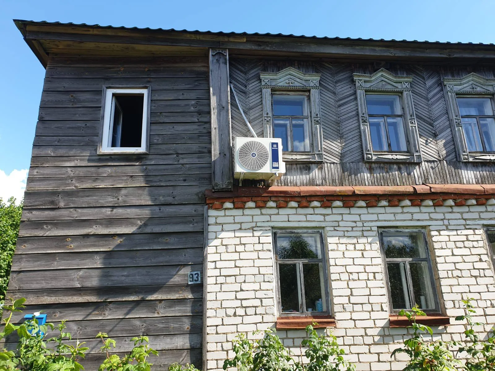 Наружный блок на деревянной части старого дома с кирпичным нижним этажом