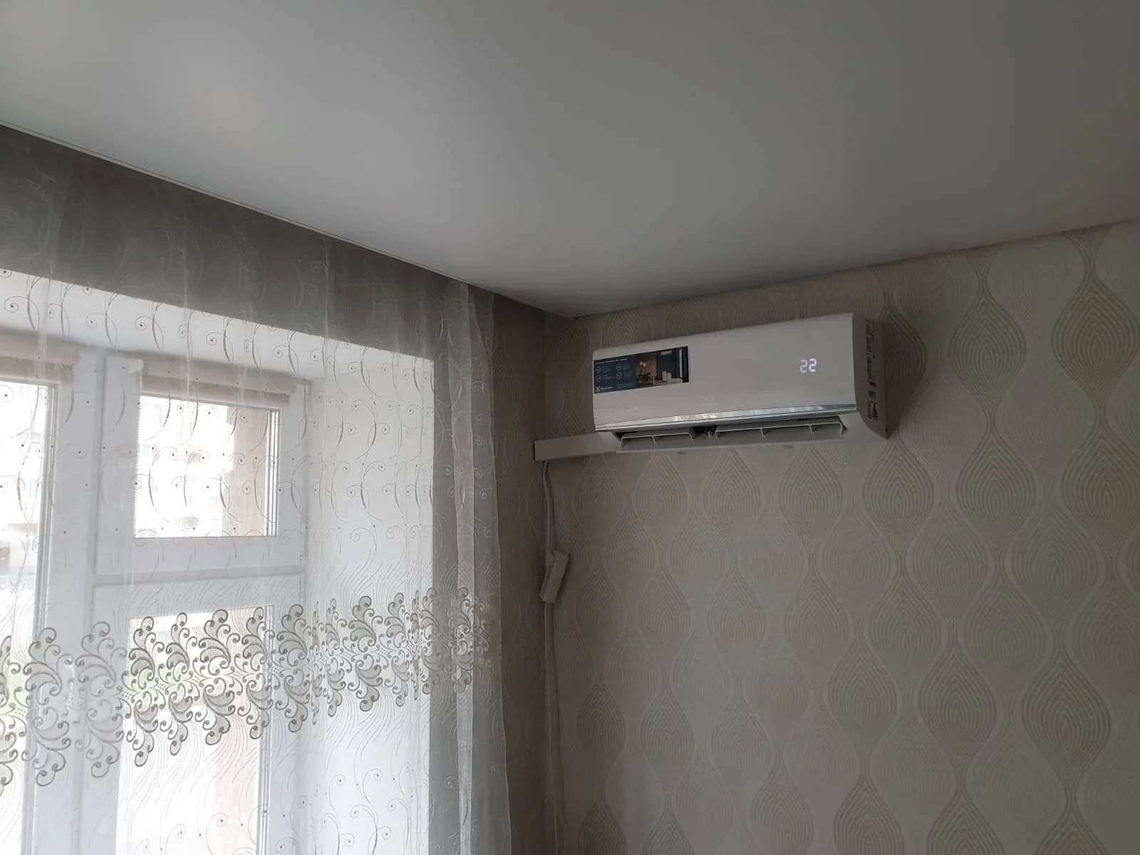Внутренний блок установлен в углу у окна; трасса закрыта коробом